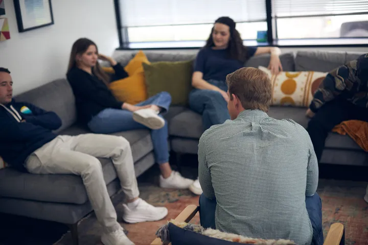 A Luna clinician in session with clients in a comfortable group room